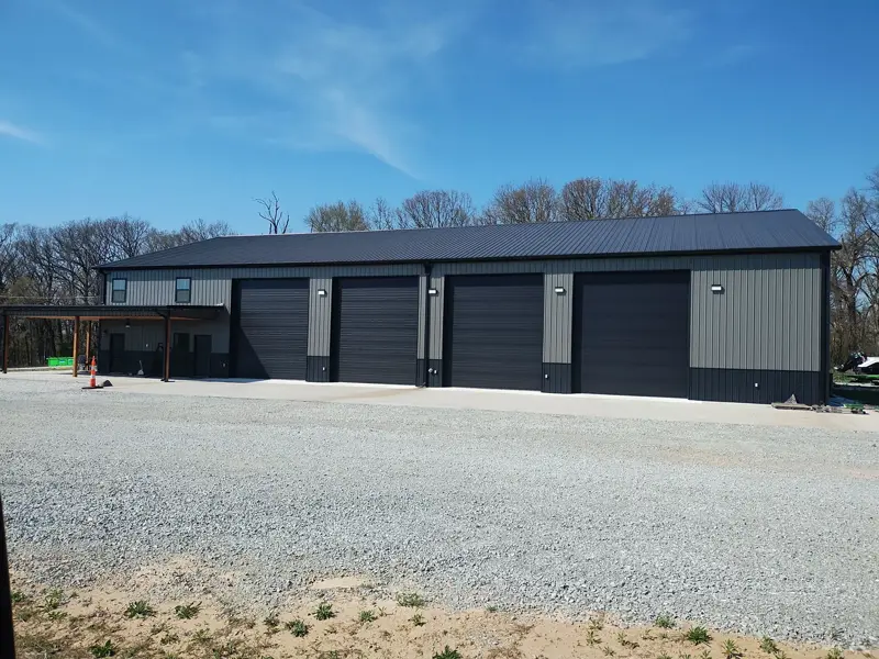 Steel building with four black overhead doors